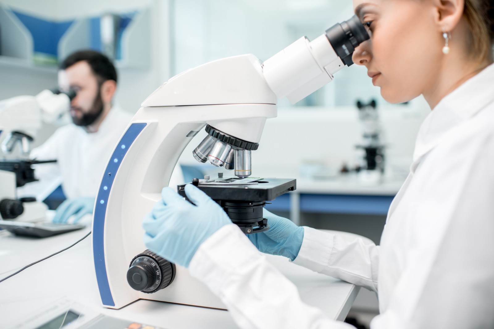 sciemtist looking through microscope